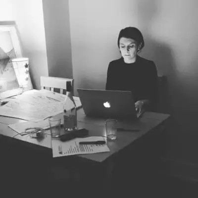 Black-and-white photo of a woman working at a laptop